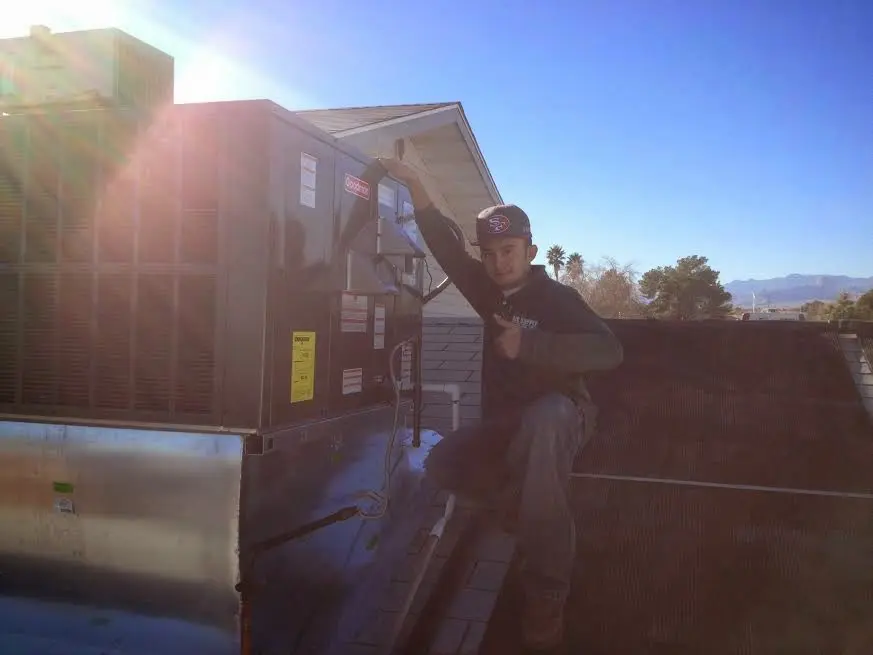 HVAC technician performing Boiler Repair on a rooftop unit in Riverview