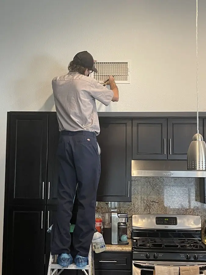 Technician inspecting an air vent during HVAC service in Riverview